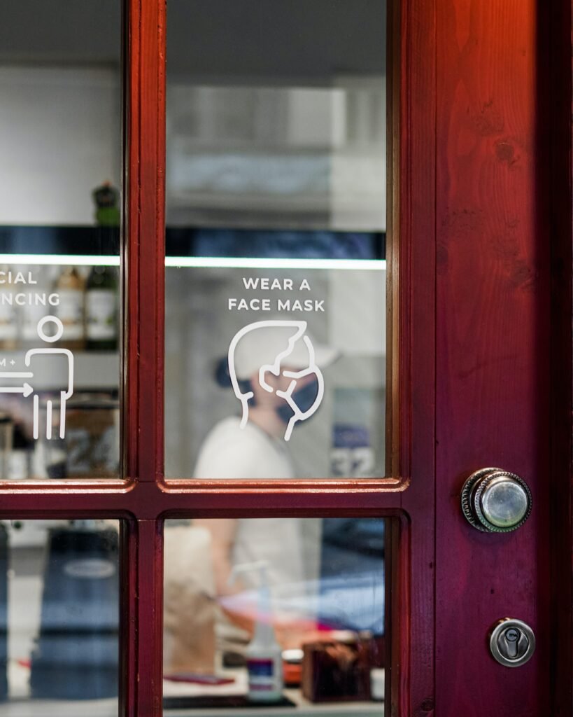 Front of a glass panel door with a "wear a face mask" sign on it