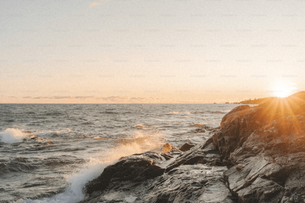 Waves spray up the rocks as the sun rises