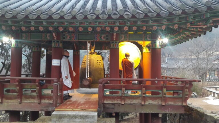 Two monks about to ring a bell in a Korean temple
