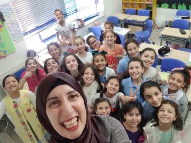 Wiam Najjar selfie shot with young students in a classroom