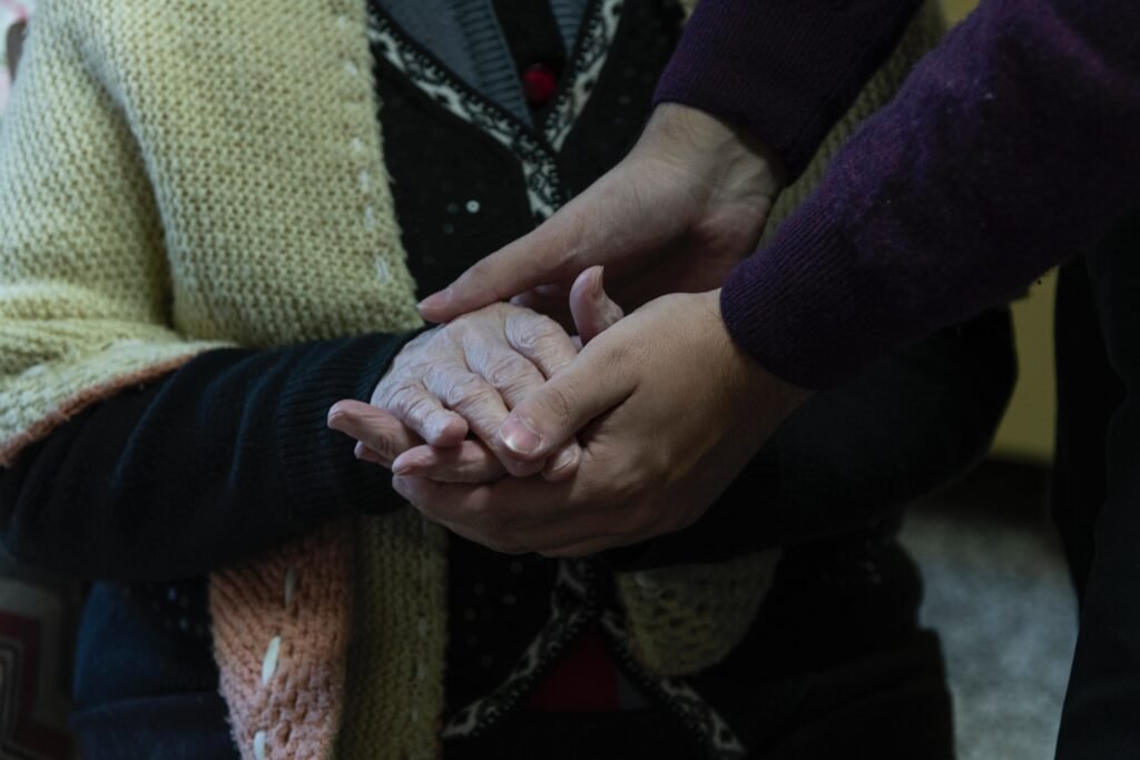 Several hands clasped together, one old and one young