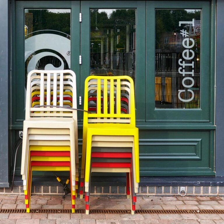 colorful chairs stacked on top of each other in front of a coffee shop window