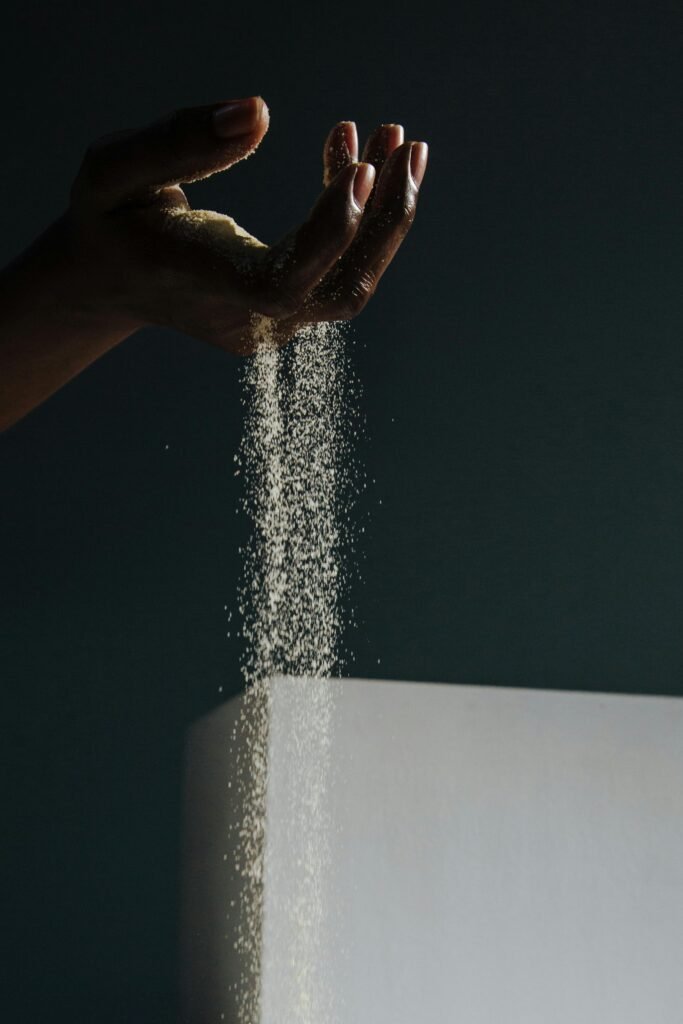 Sand falls through the fingers of an upturned hand.